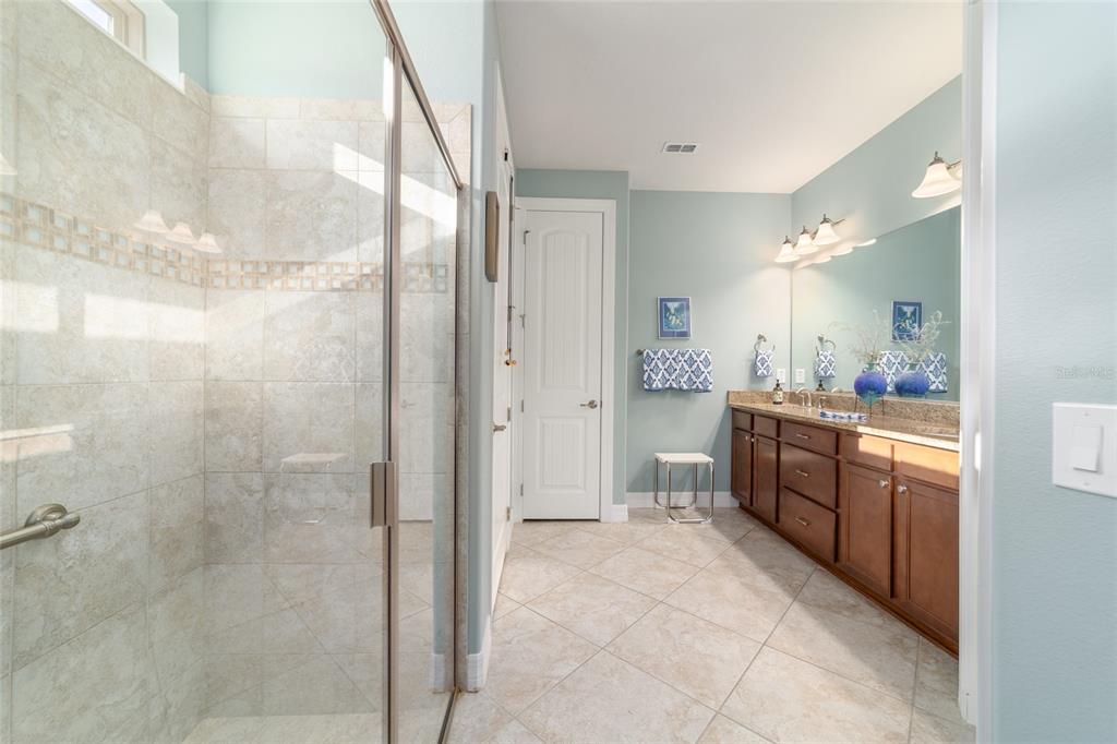 10106 Southwest 77th Loop Ocala, FL 34481 - Photo 34 of 69 a bathroom with a granite countertop sink mirror and a bathtub