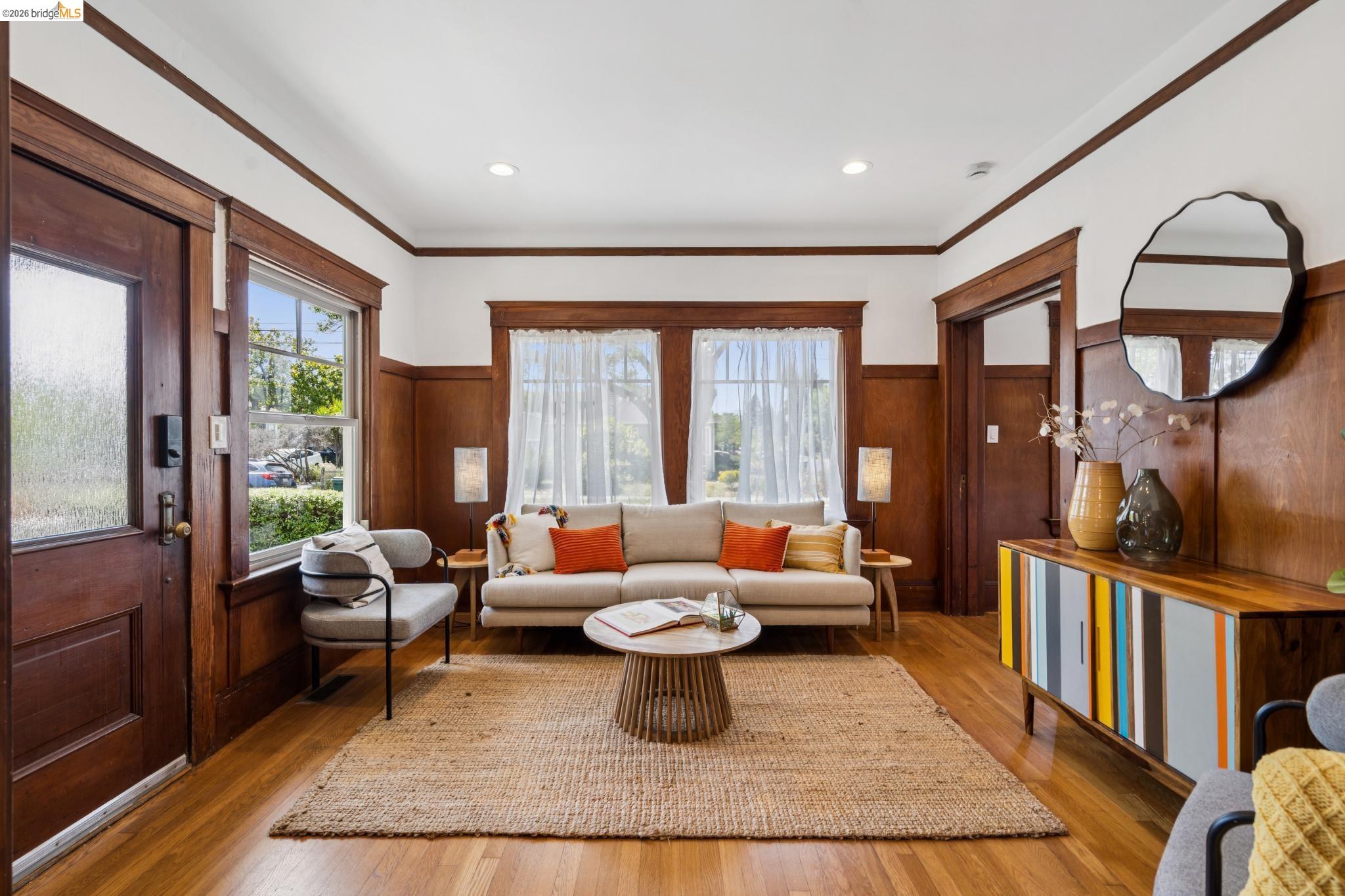 1701 Derby Street Berkeley, CA 94703 - Photo 9 of 39 Hardwood flooring throughout featuring wood paneling, extensive trim work, and a paneled entry door