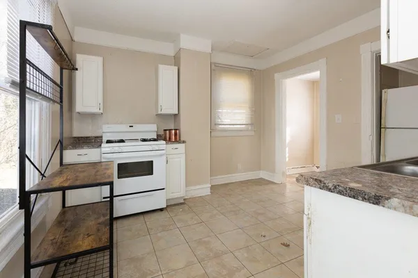 a kitchen with stainless steel appliances granite countertop a sink and a white refrigerator