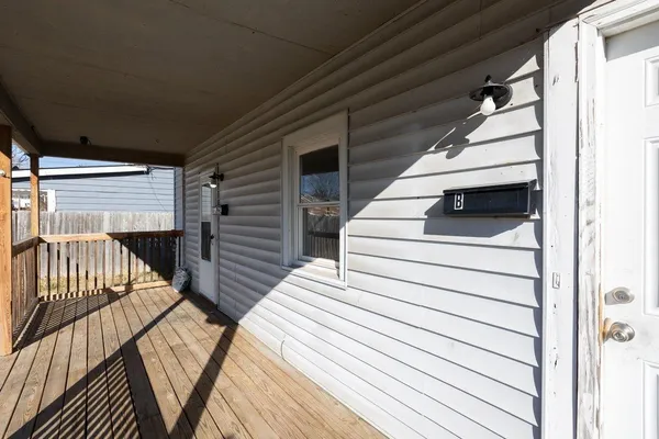 a view of a white house with large windows and a small yard