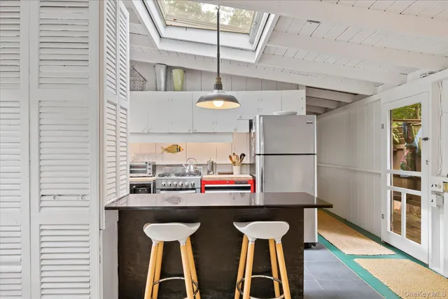 a kitchen with stainless steel appliances granite countertop a sink and a refrigerator