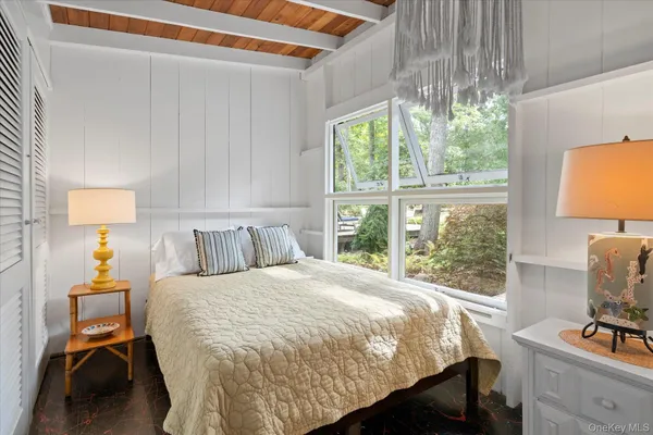 a bedroom with a bed a lamp and a window