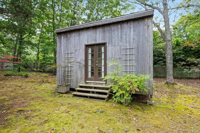 a backyard of a house with potted plants and large tree