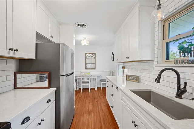 a kitchen with stainless steel appliances a refrigerator sink and white cabinets