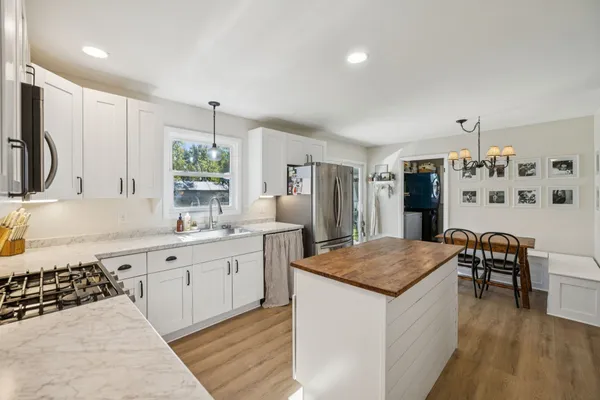 a kitchen with stainless steel appliances granite countertop a sink stove and refrigerator