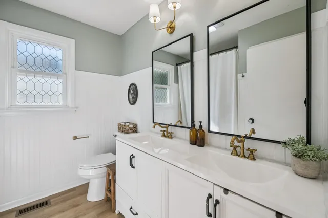 a bathroom with a granite countertop sink mirror and toilet