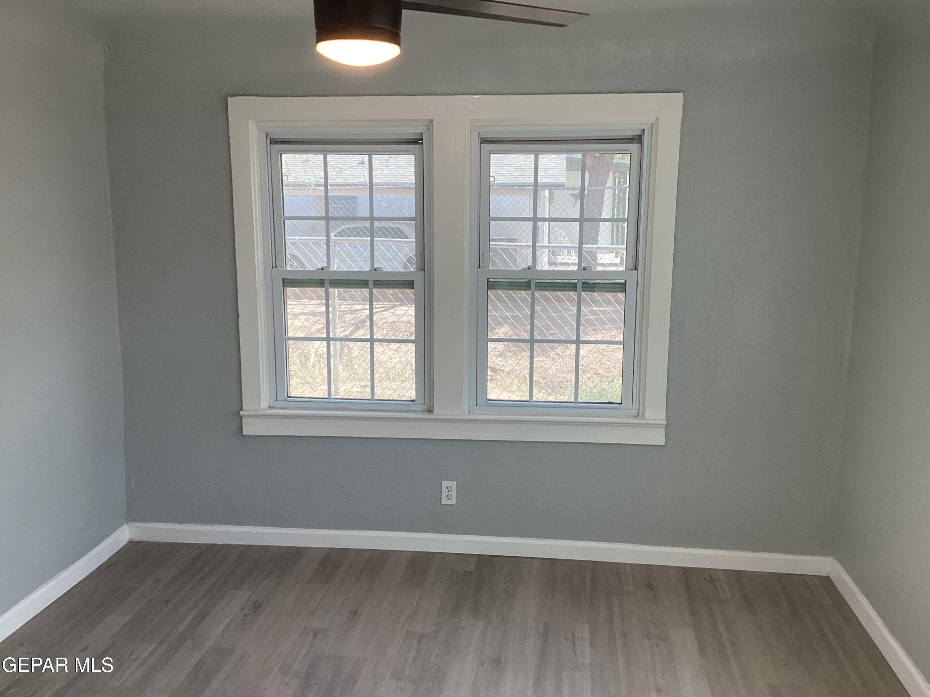 8405 Pinon Street El Paso, TX 79907 - Photo 8 of 21 an empty room with wooden floor and windows