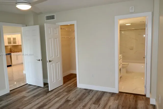 an empty room with wooden floor and closet