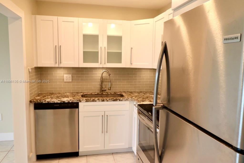 4164 Inverrary Drive, Unit 408 Lauderhill, FL 33319 - Photo 6 of 14 a kitchen with stainless steel appliances granite countertop a sink stove and refrigerator