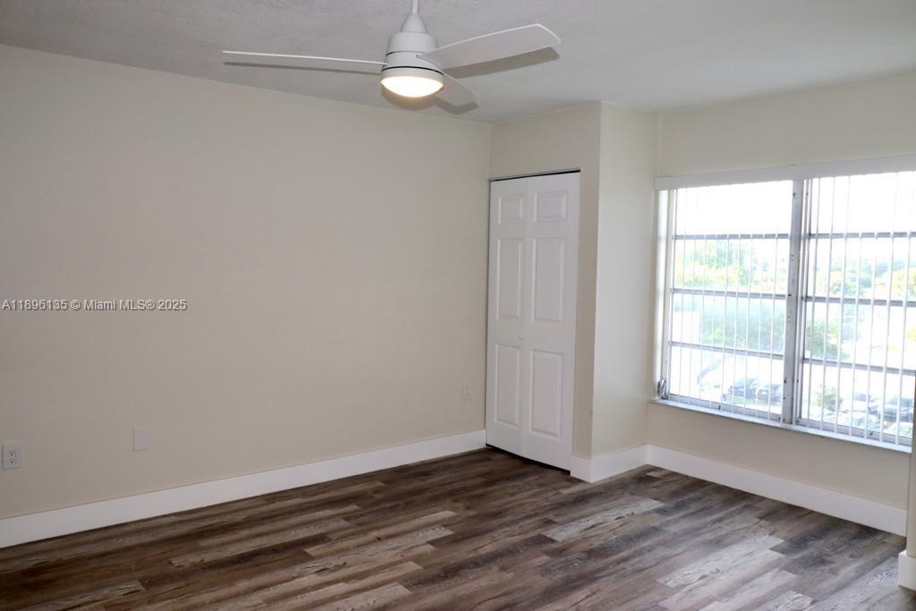 4164 Inverrary Drive, Unit 408 Lauderhill, FL 33319 - Photo 10 of 14 an empty room with wooden floor and windows