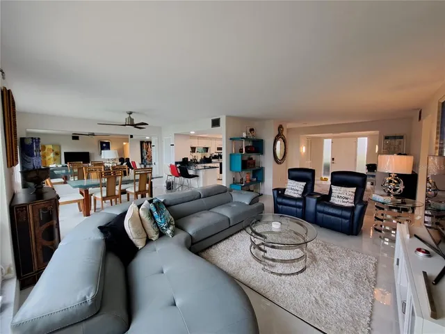 a living room with furniture and a view of kitchen
