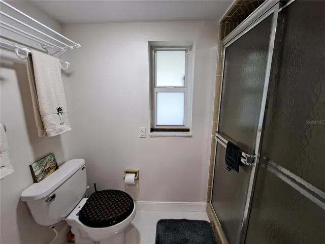 a bathroom with a sink a toilet a mirror and shower