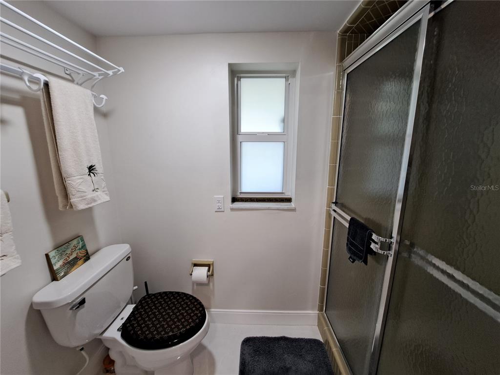 1 Colony Point Drive, Unit A5 Punta Gorda, FL 33950 - Photo 20 of 37 a bathroom with a sink a toilet a mirror and shower