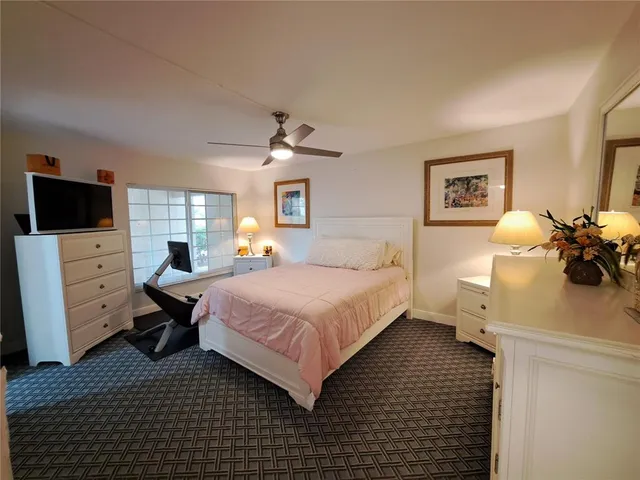 a bedroom with a bed and a tv on the dresser