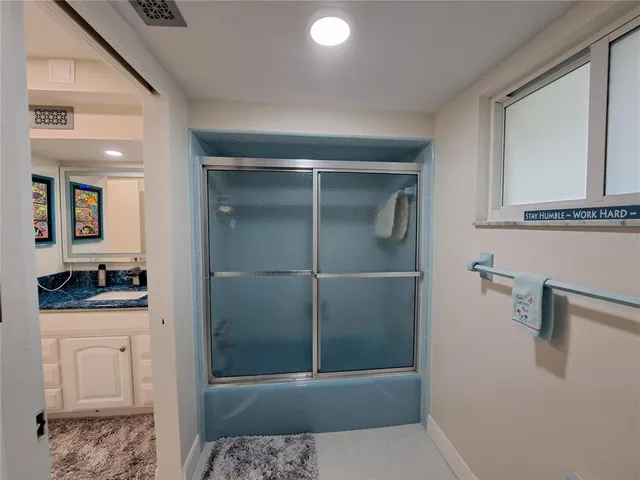 a bathroom with a granite countertop sink a toilet and shower