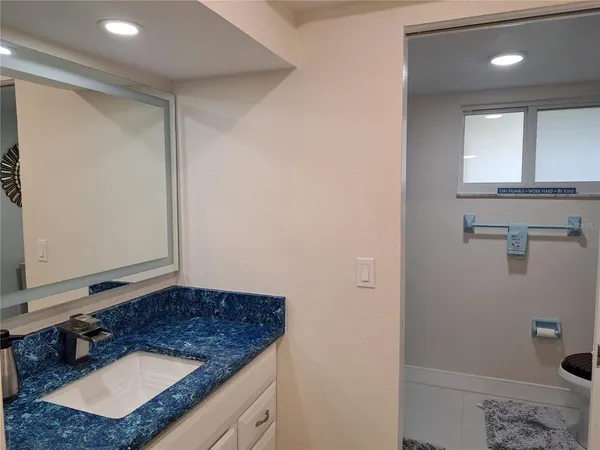 a bathroom with a granite countertop sink and a mirror