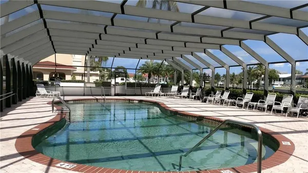 a view of a swimming pool with a table and chairs under an umbrella