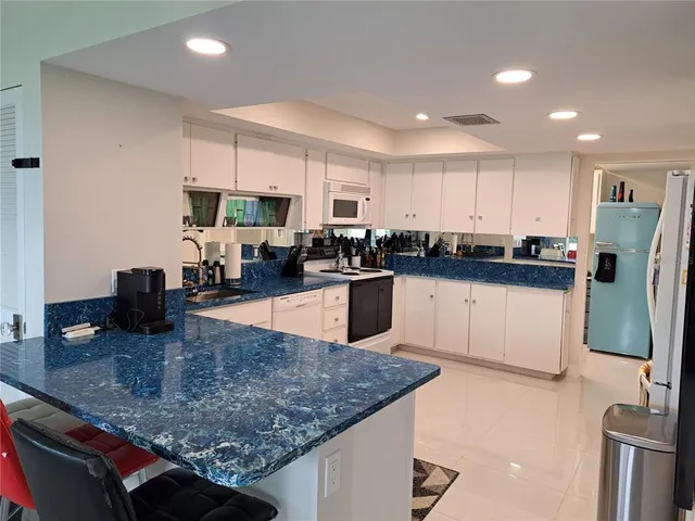 a kitchen with stainless steel appliances granite countertop a sink a stove and a refrigerator