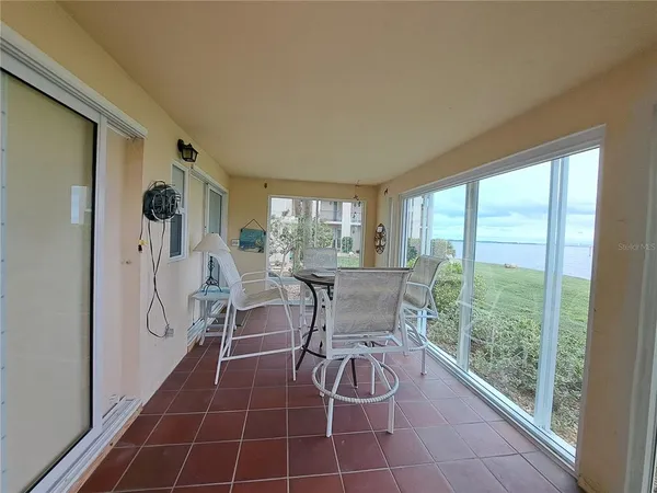 a dining room with furniture and a floor to ceiling window