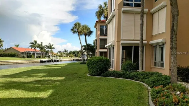 a front view of multi story residential apartment building with yard and green space