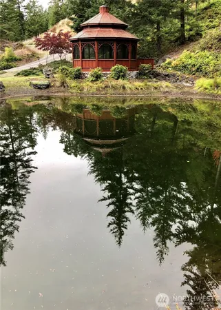 a view of a lake with a table and chairs under an umbrella