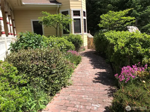 a front view of a house with a yard and flowers