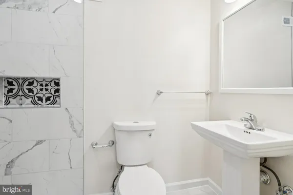 a bathroom with a toilet sink and mirror