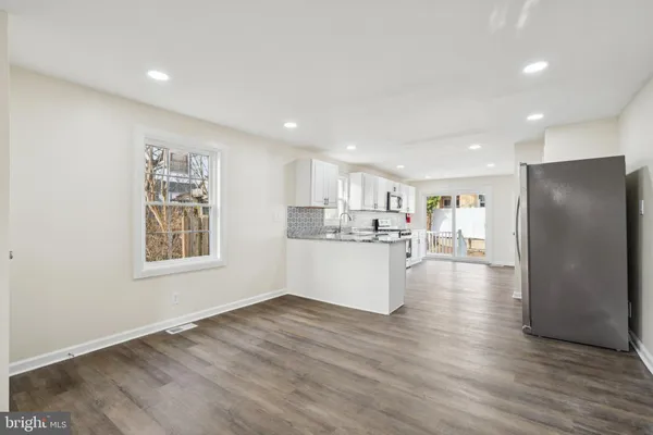 a view of a kitchen with a refrigerator and wooden floor