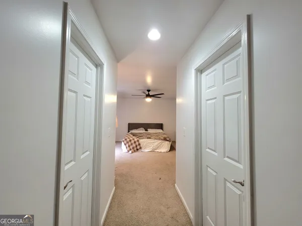 a view of a hallway and a livingroom with a glass door