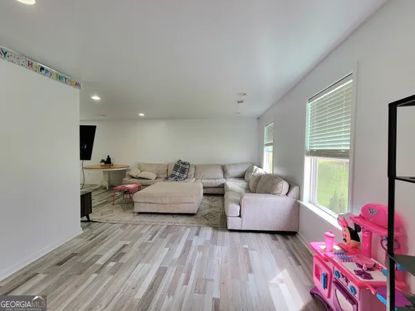 a living room with furniture and wooden floor