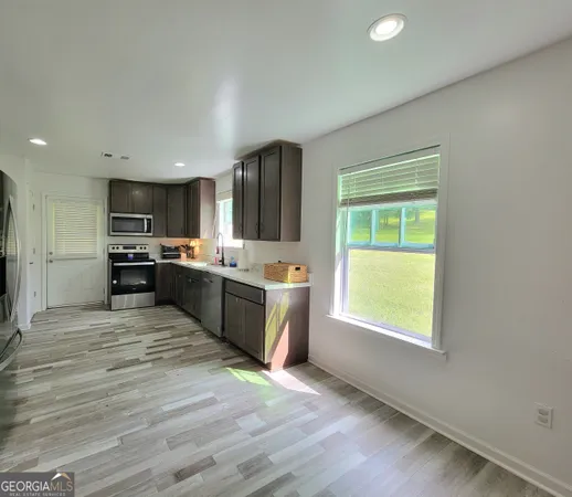 a large kitchen with a large window and stainless steel appliances