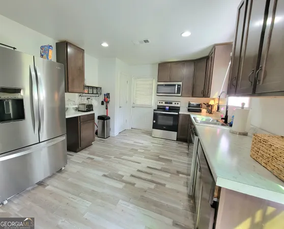 a kitchen with stainless steel appliances granite countertop a refrigerator stove and oven