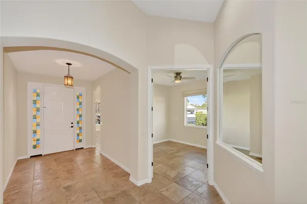 an empty room with windows and ceiling fan