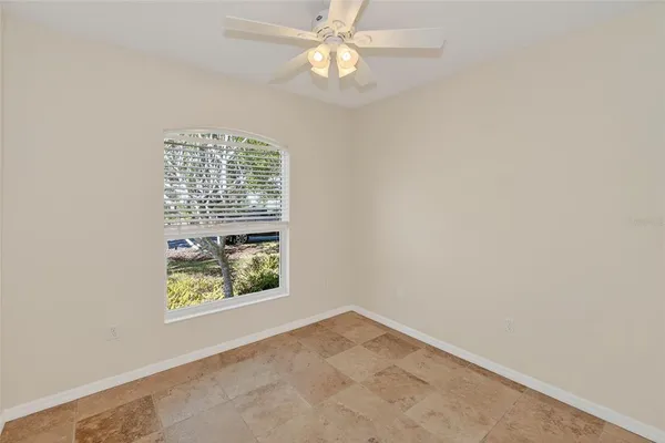an empty room with a chandelier fan
