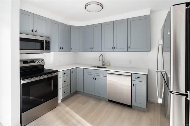 a kitchen with cabinets stainless steel appliances and a counter space