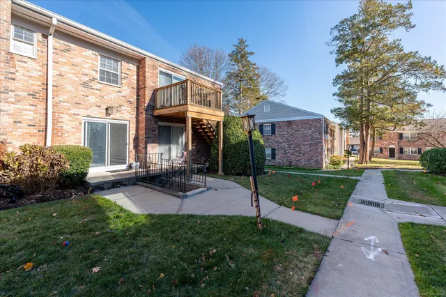 a view of a house with a yard and fire pit