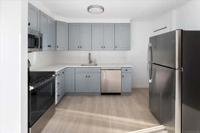 a kitchen with stainless steel appliances a refrigerator sink and cabinets