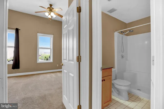 a bathroom with a granite countertop shower a toilet and a sink