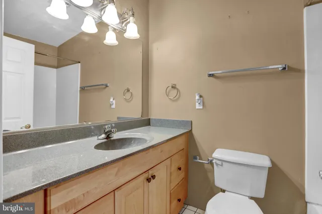 a bathroom with a granite countertop sink a toilet and a mirror
