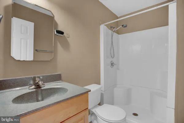 a bathroom with a granite countertop sink toilet and shower