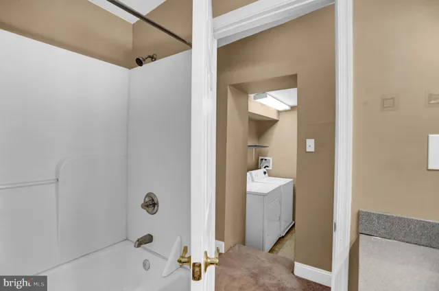a bathroom with a tub shower and a sink