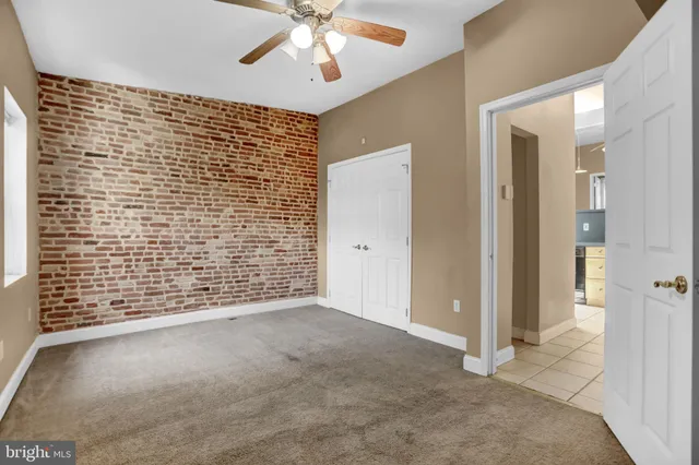 a view of an empty room and chandelier fan