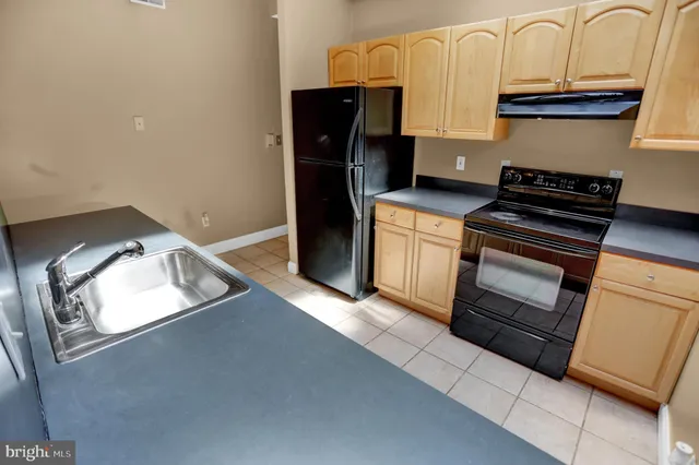 a kitchen with granite countertop a stove and a refrigerator