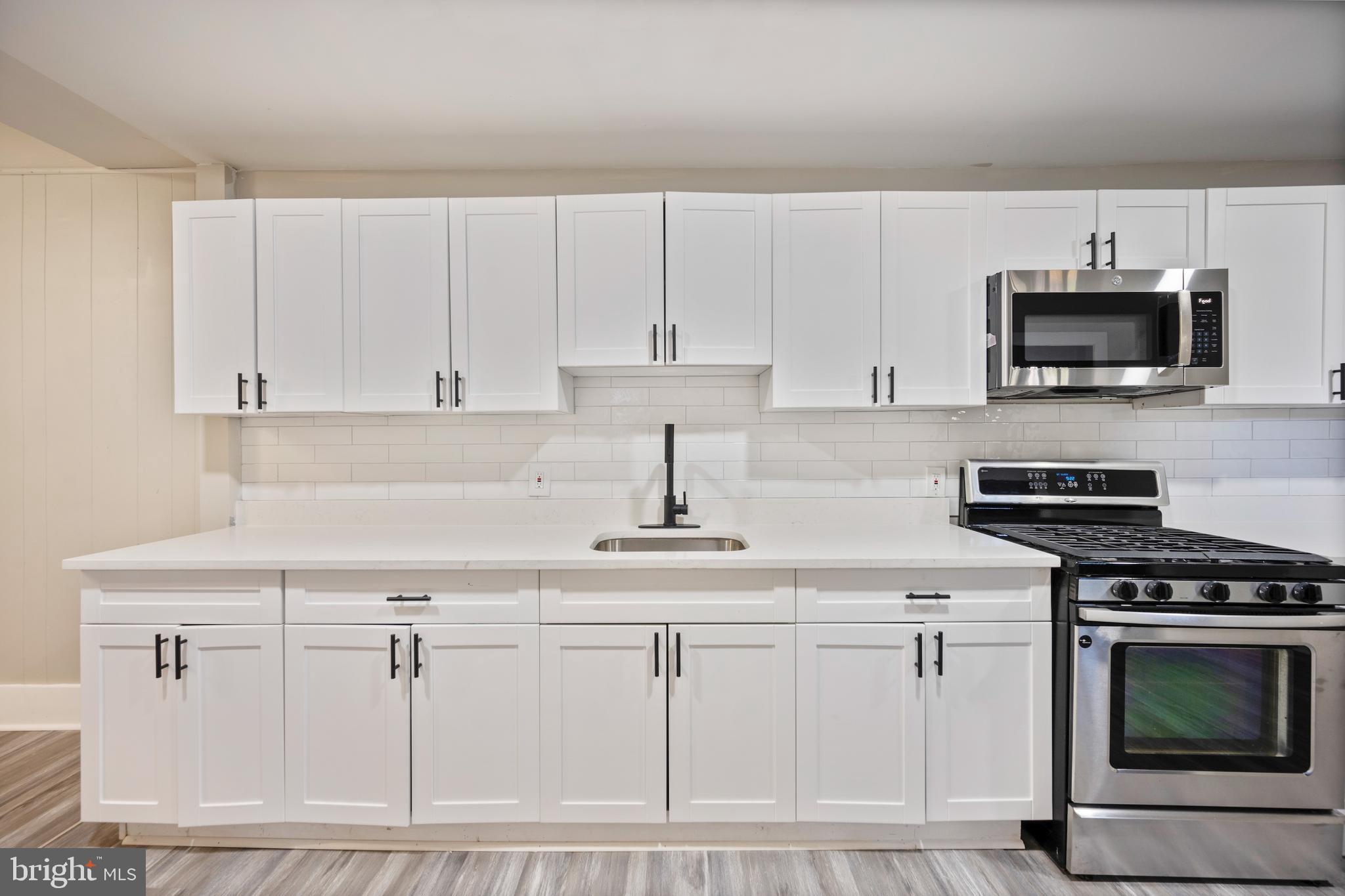 1038 Brantley Avenue Baltimore, MD 21217 - Photo 15 of 38 a kitchen with white cabinets and stainless steel appliances