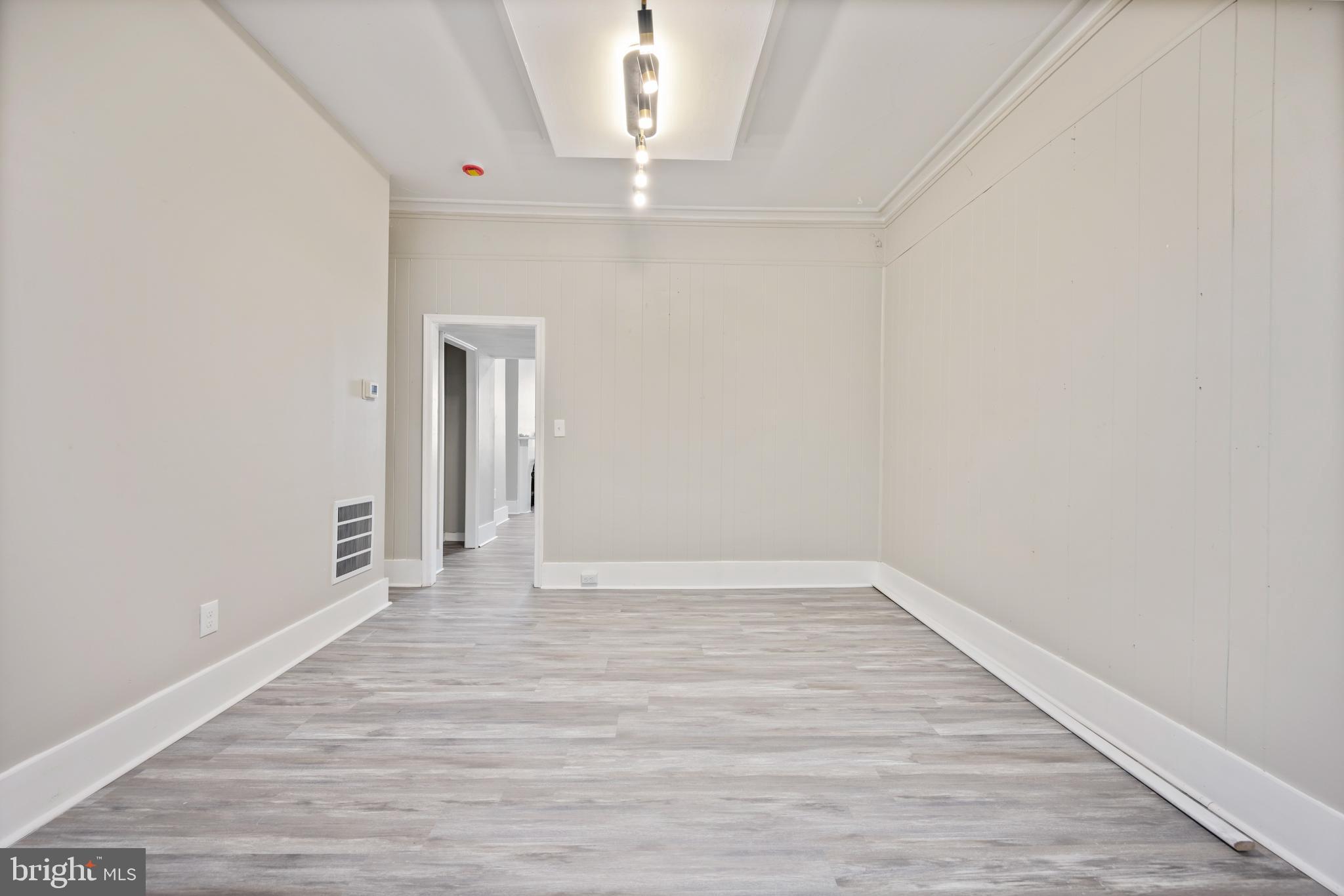 1038 Brantley Avenue Baltimore, MD 21217 - Photo 20 of 38 a view of an empty room with wooden floor and a window