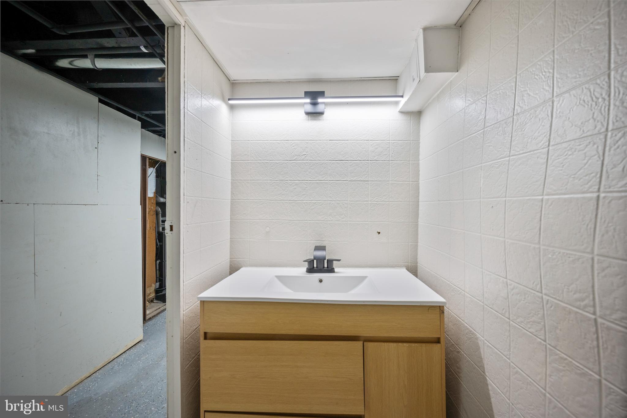 1038 Brantley Avenue Baltimore, MD 21217 - Photo 10 of 38 a bathroom with a sink and a mirror