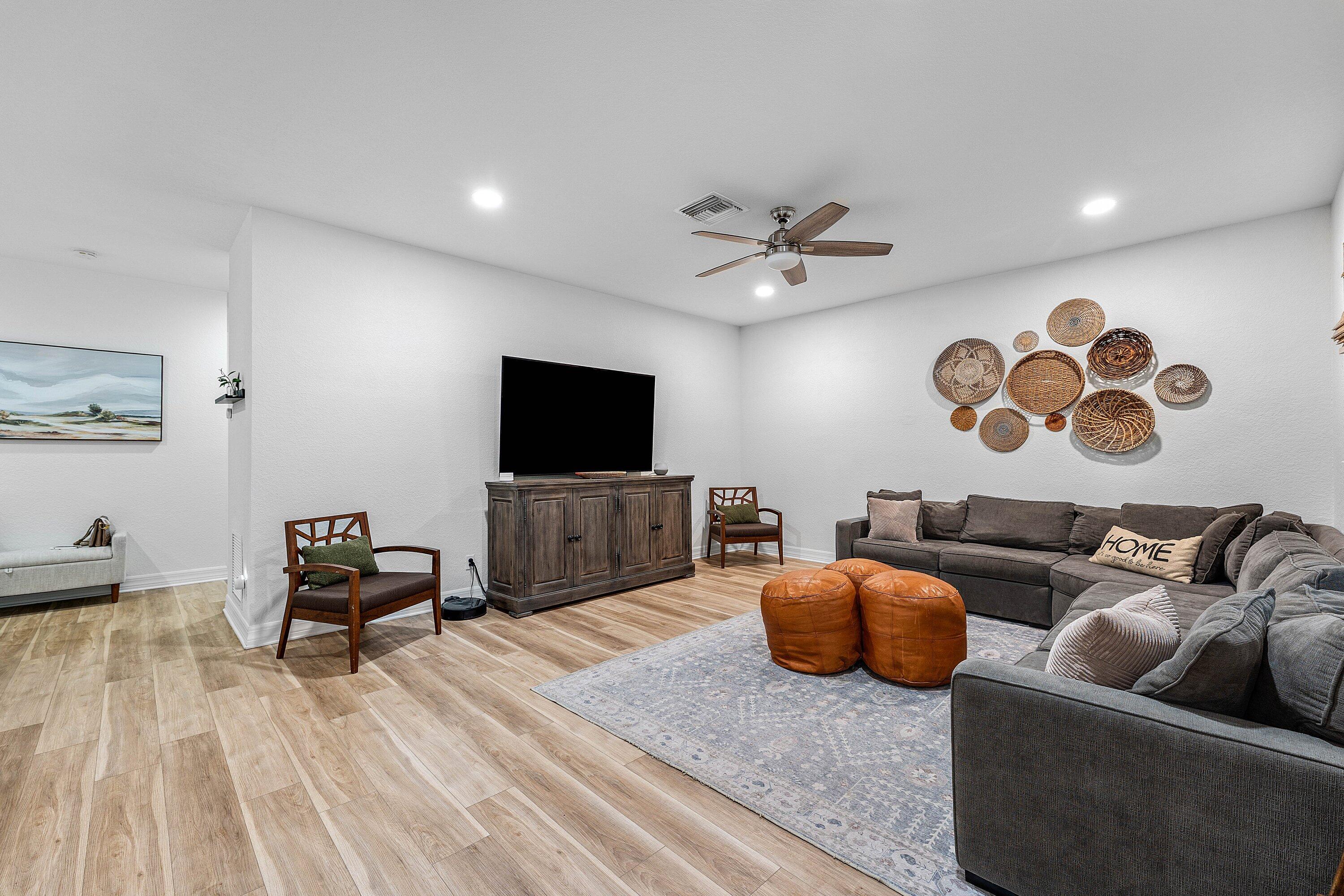 1056 Community Drive Jupiter, FL 33458 - Photo 11 of 50 a living room with furniture and a flat screen tv
