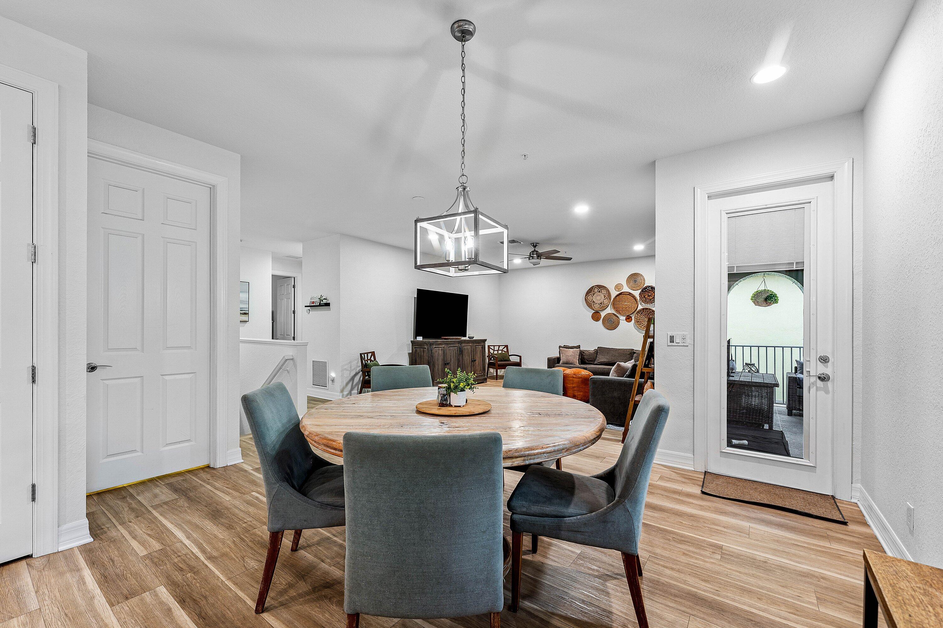 1056 Community Drive Jupiter, FL 33458 - Photo 12 of 50 a dining room with wooden floor a chandelier a wooden table and chairs