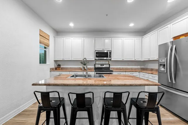 a kitchen with kitchen island cabinets and refrigerator