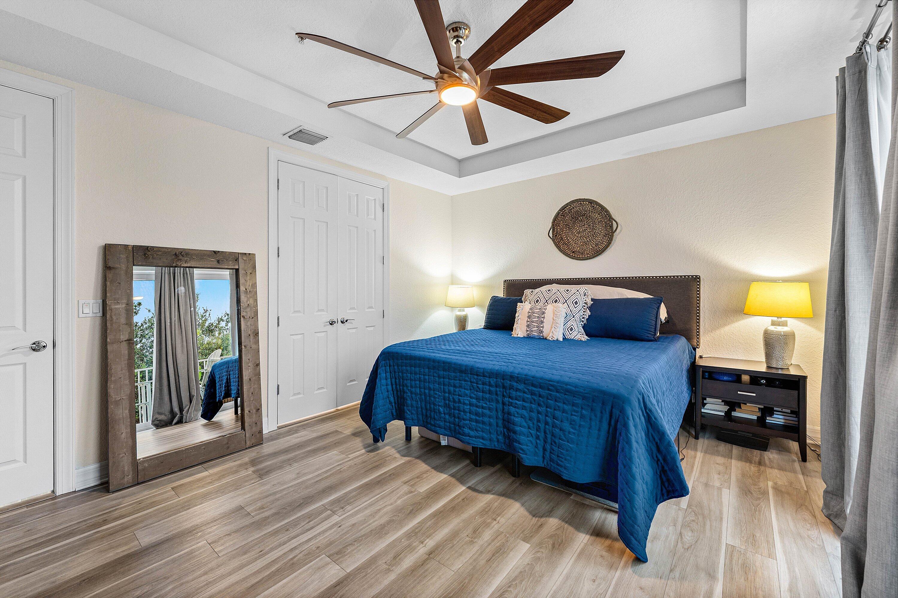 1056 Community Drive Jupiter, FL 33458 - Photo 21 of 50 a bedroom with a bed a mirror and a window